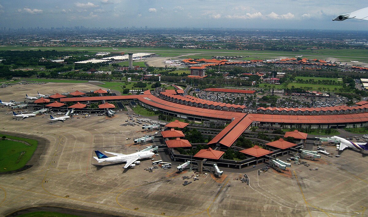 Foto dari atas menunjukkan desain atap tradisional Jawa (joglo) Terminal 1 dan 2 Bandara Soekarno-Hatta (CGK) dengan pesawat Garuda Indonesia dan maskapai lainnya di landasan pacu dan area parkir.
