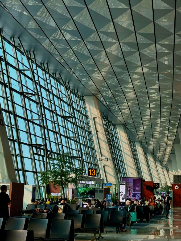 Arsitektur atap modern dan area check-in yang ramai di Terminal 3 Ultimate Bandara Soekarno-Hatta.
